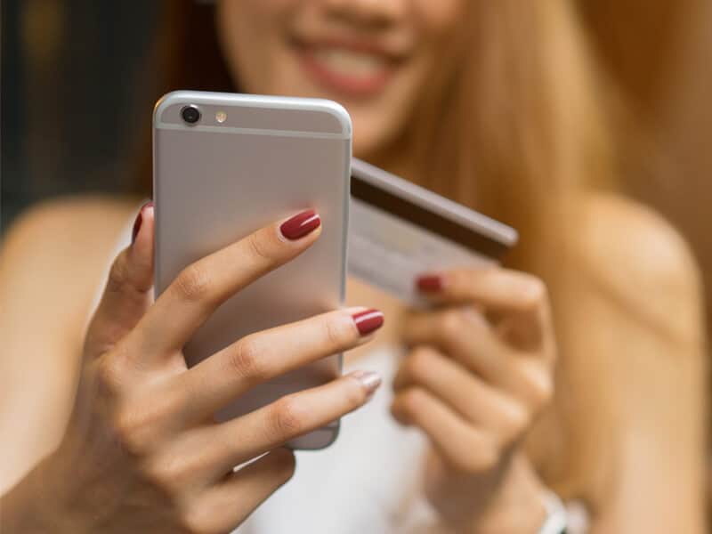 Woman making a payment on her phone Woman making a payment on her phone